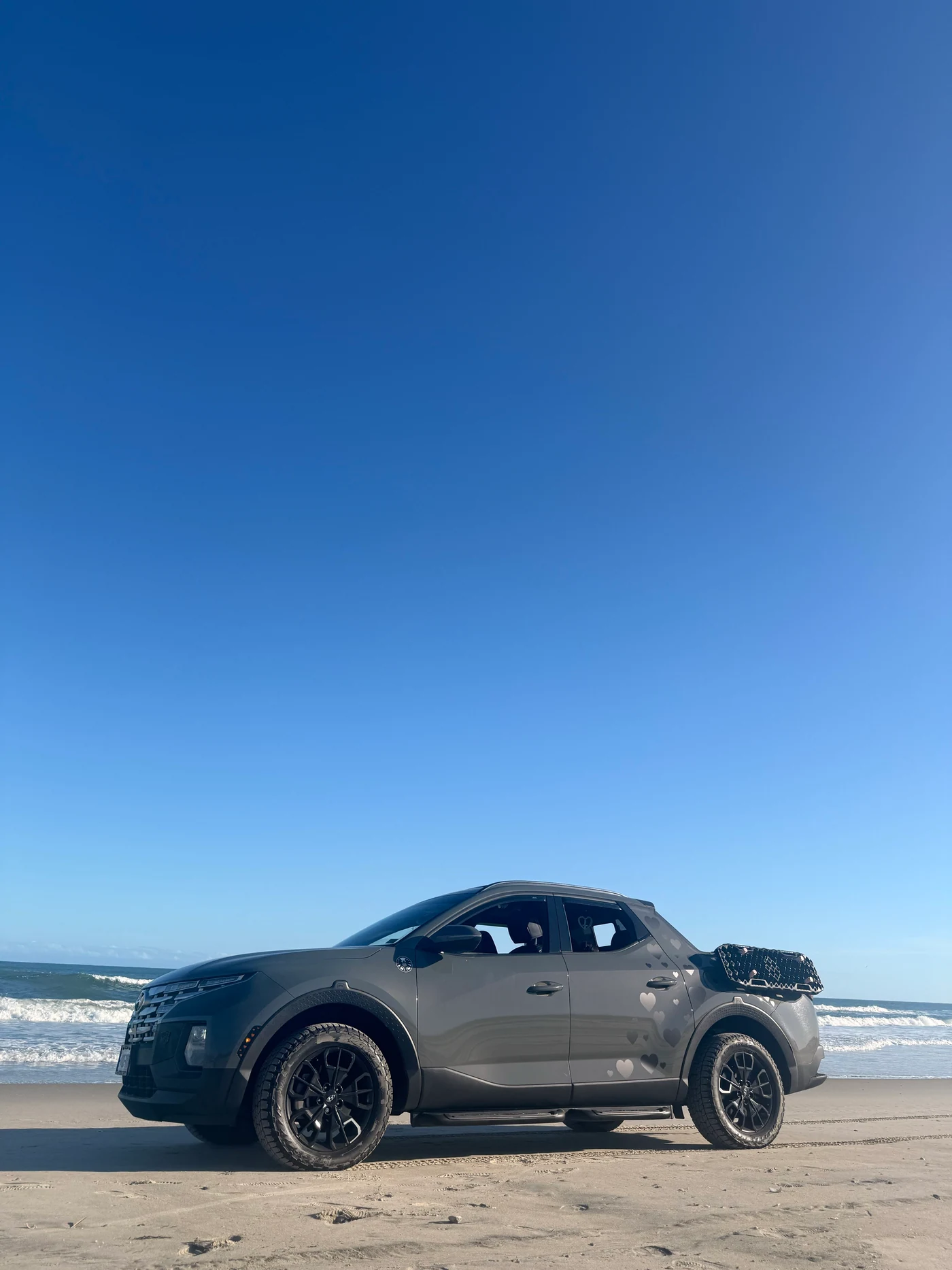 A modified Hyundai Santa Cruz parked on a beach.